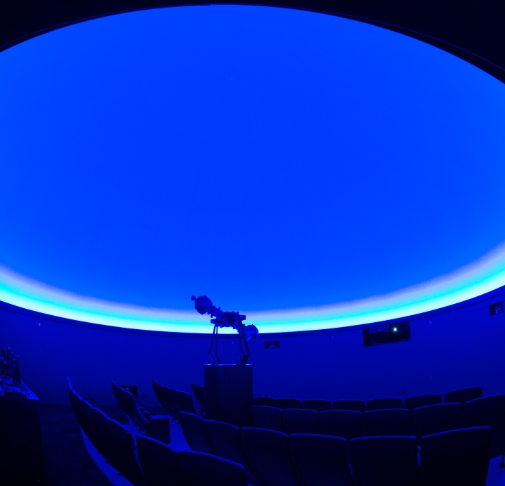 theater-like seating under a large dome lit with blue